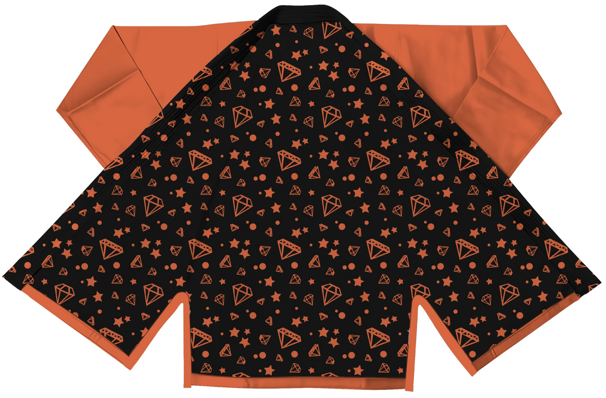 Orange gi for kids displayed with pearl weave jacket and ripstop pants